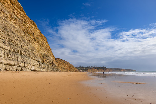 Praia de Porto Mos sandy beach and cliff in Lagos, resort town on Algarve coast in Faro District, southern Portugal.