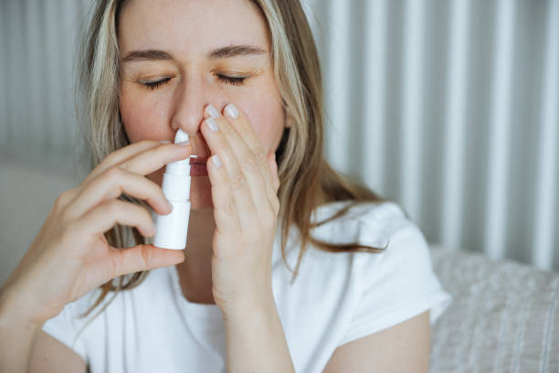 istock Sick young woman using nasal spray 2147519597