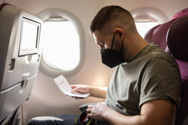 istock Passenger reviewing ticket on airplane 2147519738