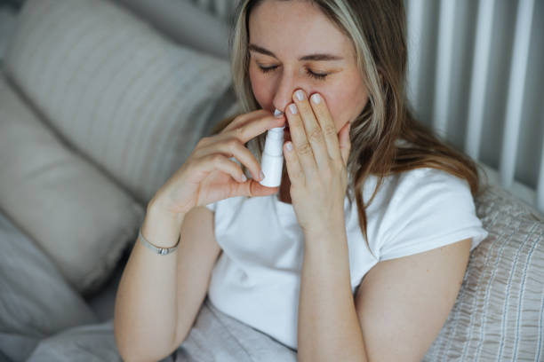 istock Sick young woman using nasal spray 2147519937