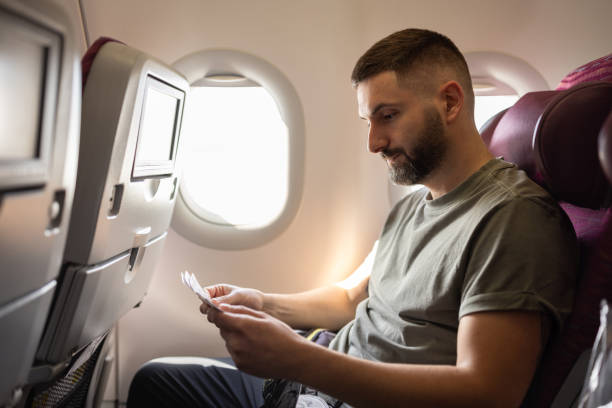 istock Man reviewing ticket on airplane 2147519974