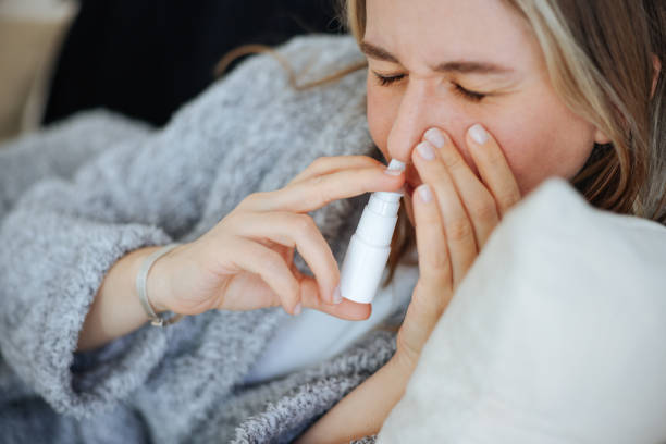 istock Sick young woman using nasal spray 2147519984