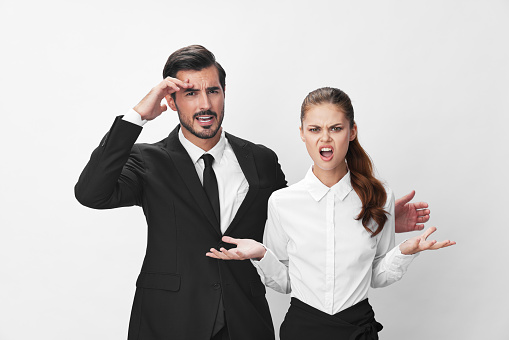 Man and woman anger business in business at each other shouting with their hands up in the air against a white isolated background. The concept of business in a couple harassment startup copy space. High quality photo