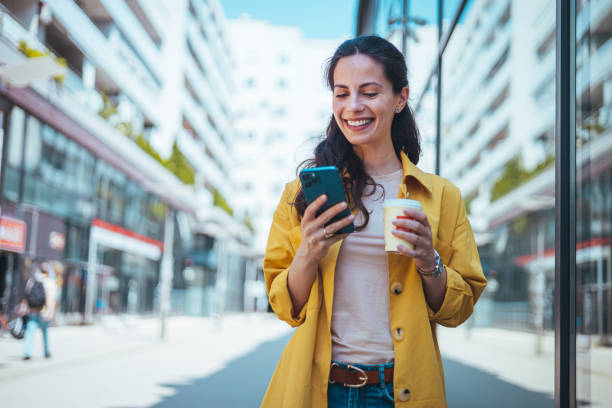 istock Woman texting and drinking coffee outdoors. 2147521257