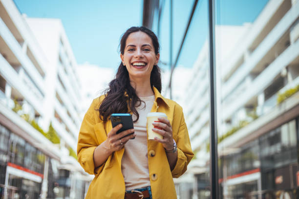 istock Woman texting and drinking coffee outdoors. 2147521327
