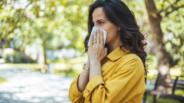 istock Woman with allergy symptoms blowing nose. 2147521565