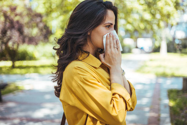 istock Woman with allergy symptoms blowing nose. 2147521576