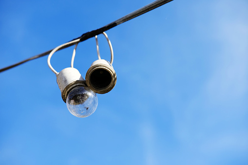 Equipped and electrical with light bulbs is hanging in the wind and sunlight on blue sky