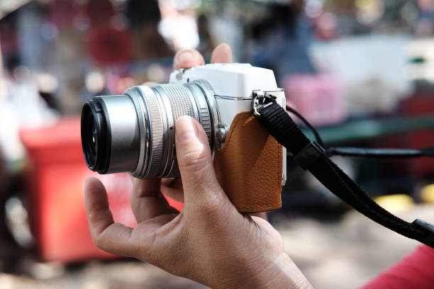 istock Close up hand holding vintage digital mirrorless camera 2147523064