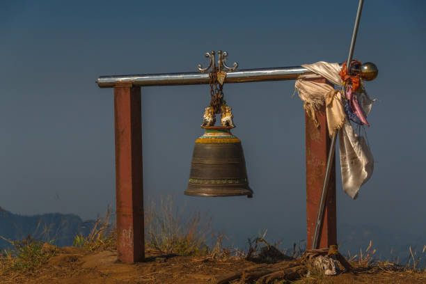 A bell hanging from a metal pole with a white cloth draped over it