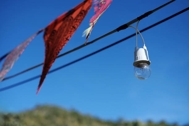 istock Equipped and electrical with light bulbs is hanging in the wind and sunlight on blue sky 2147526455