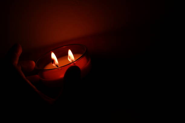burning candle close up. woman's hand holding a burning candle