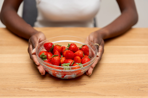 Close-up of Fresh Red Strawberries in a Glass Bowl Held by Woman