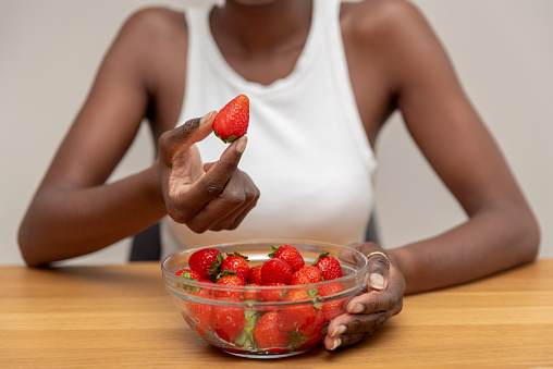 close up of Woman Picking a Strawberry from a Bowl Full of Fresh strawberries