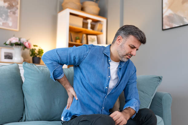 istock Handsome man touching his back, suffering from backpain, sciatica, sedentary lifestyle concept. Spine health problems. Healthcare, insurance 2147529471