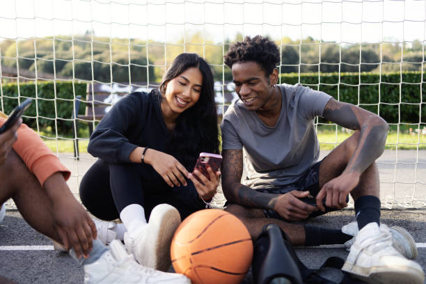 istock Multi-ethnic friends using phone after playing basketball 2147529534