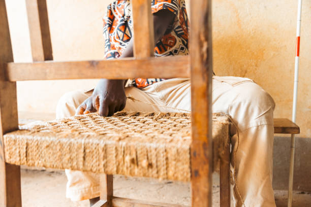 A disable man is handcrafting a chair, social inclusion of people with disabilities.