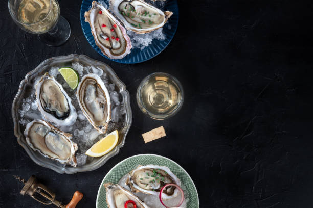 istock Oysters on ice, with various toppings and white wine, overhead flat lay shot 2147531058