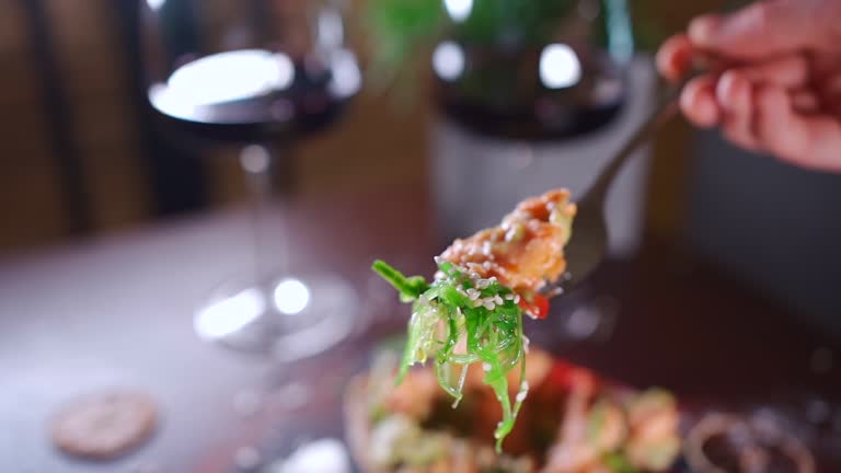 person eats fresh sandwich with avocado, red salmon fried fish, seaweed, pepper