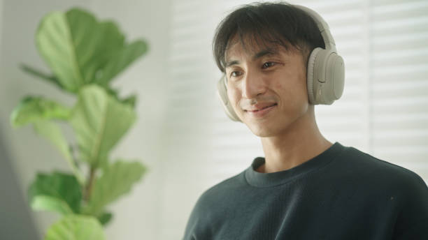 istock Asian man resting with tea or coffee while watching on laptop. 2147531803