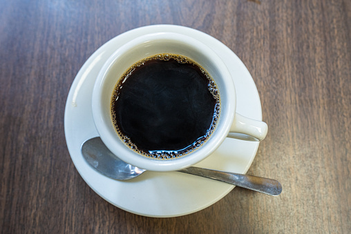 Black americano coffee on wooden table.