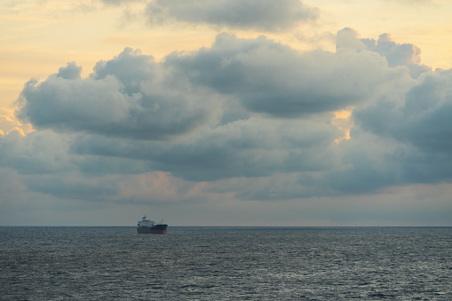 Dry cargo ship in the Baltic sea at dawn, sky with clouds. High quality photo