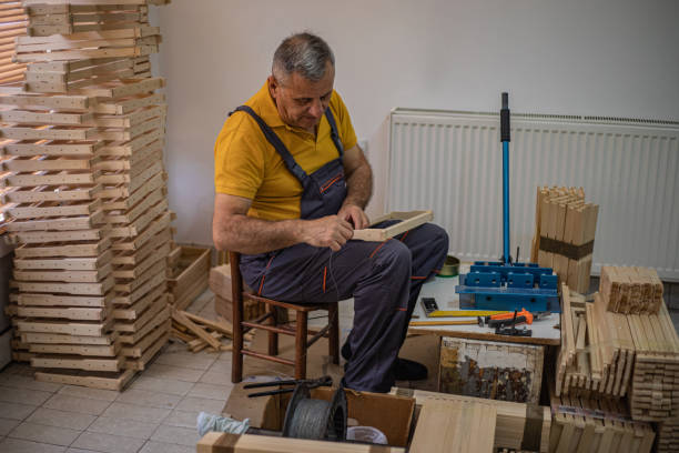 A carpenter assembles wooden frames for beehives, beekeeping equipment