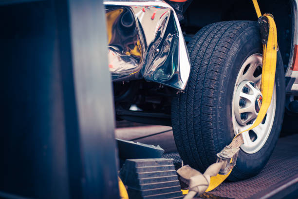 istock Toned photo smashed bumper front fender on pickup truck by car accident on flatbed rollback tilt tray of tow truck with yellow ratchet strap tie down, collision, insurance claim concept, Texas 2147534429