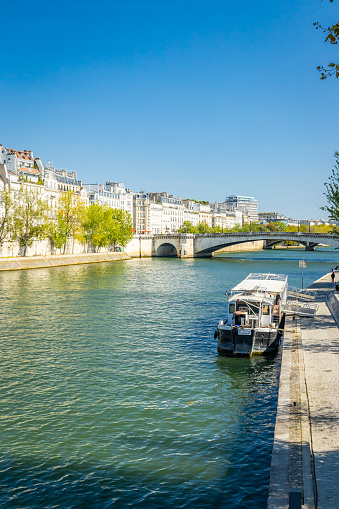 Paris, France - September 10, 2023 : Seine river and buildings of the Quai d'Orleans of the Ile Saint-Louis on a summer day