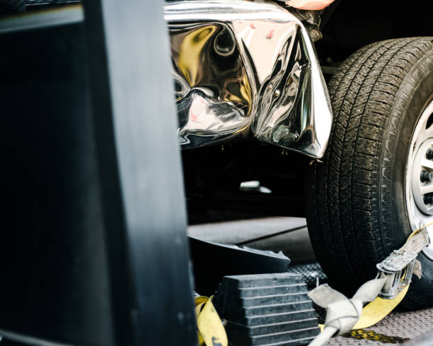 istock Smashed bumper front fender on pickup truck by car accident carrier on flatbed rollback slide tilt tray of tow truck with yellow ratchet strap tie down, collision, insurance claim concept, Texas 2147535151