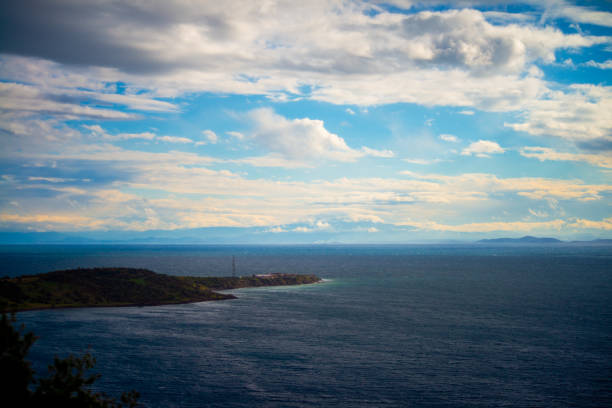 A serene view of a coastal peninsula, where land meets the sea, creating a picturesque scene of nature's beauty and the tranquil horizon over the water.