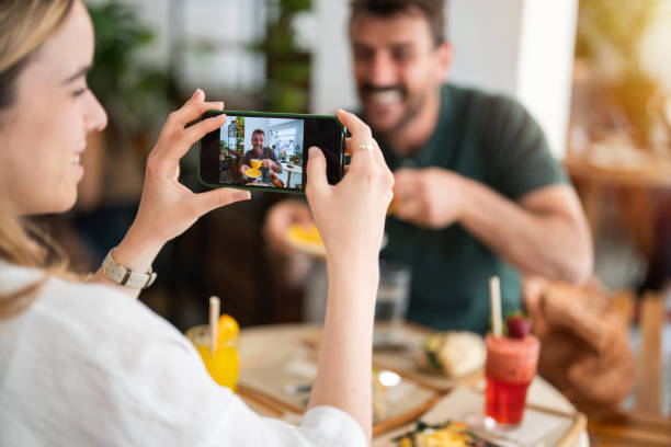 istock Happy man being photographed by his girlfriend while drinking coffee in a cafe. 2147535721
