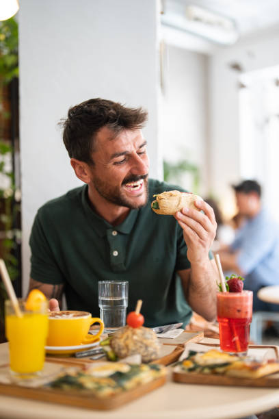 istock Caucasian bearded middle-aged man with an appetite eating sandwich. 2147535880