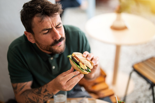 Bearded man having a sandwich for breakfast
