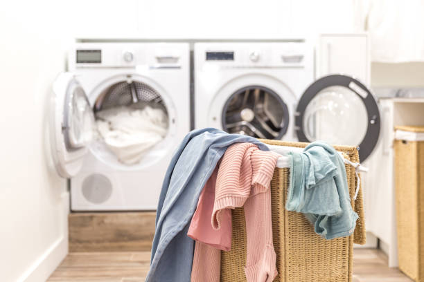 istock Laundry room with basket and washing and drying machines on background 2147537228