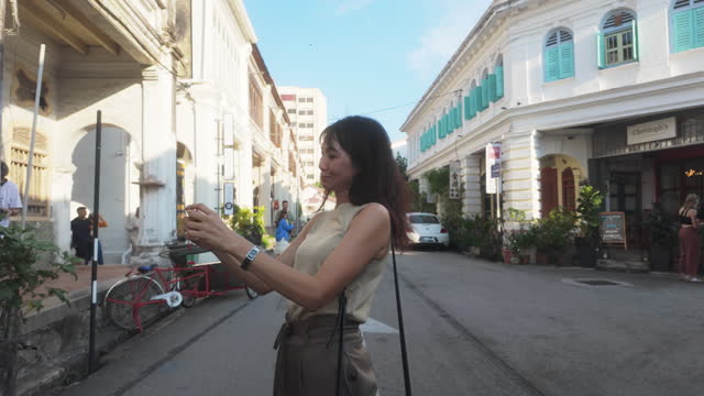 Asian mature female tourist exploring Penang old town, Malaysia