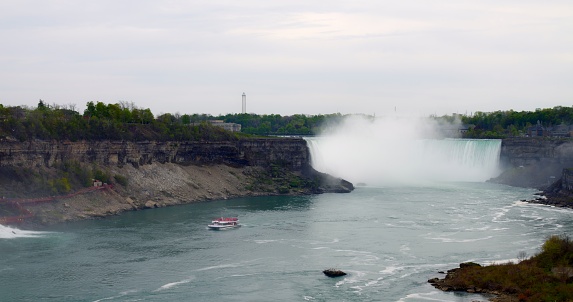 Natural beauty of Niagara River Falls complex from distance in daylight. Behold stunning view of waterfall complex in all its glory. Majesty of waterfall complex, cascading gracefully in daylight