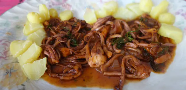 Squid flambéed with cognac then cooked with Armorican sauce  Meal served with steamed potatoes