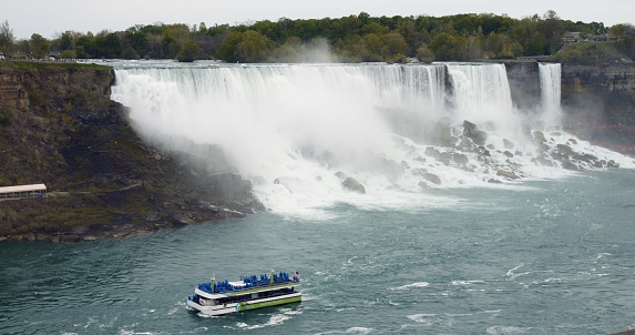 Wonderful summer trip aboard Maid of the Mist to majestic Niagara Falls. American-Canadian border from deck of iconic excursion ship. International travel concept on cruise ships in North America.