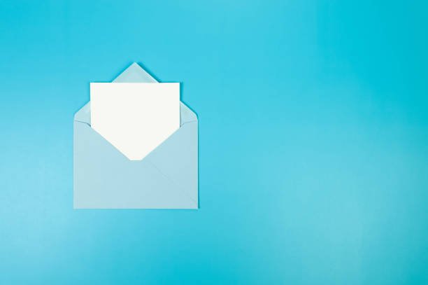 istock Top view of light blue envelope, white card on blue background. 2147542812