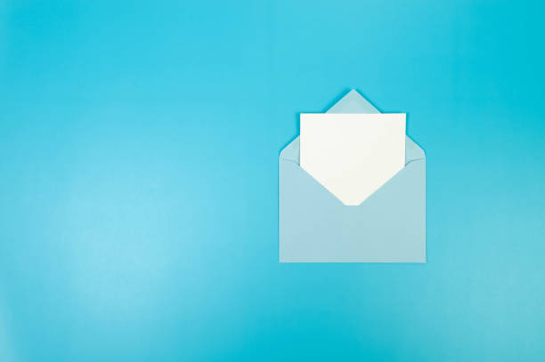 istock Top view of light blue envelope, white card on blue background. 2147542815