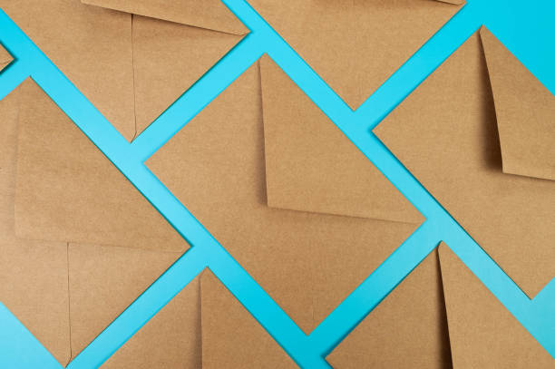 istock Top view of brown kraft envelopes on blue background. 2147542837