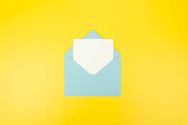 istock Top view of light blue envelope, white card on yellow background. 2147542904