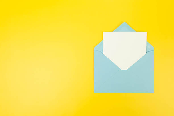 istock Top view of light blue envelope, white card on yellow background. 2147542907