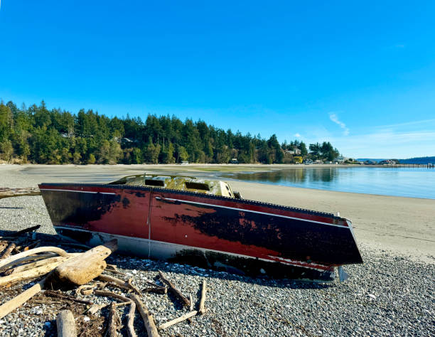istock Beached sailboat during low tide with coastal community in background 2147542930