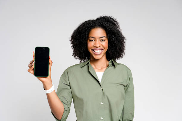 istock Beaming with joy, this African-American woman showcases her phone with empty screen 2147543476