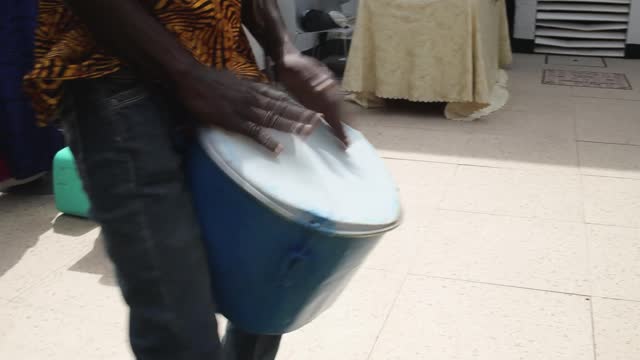 A person beating a drum with hands