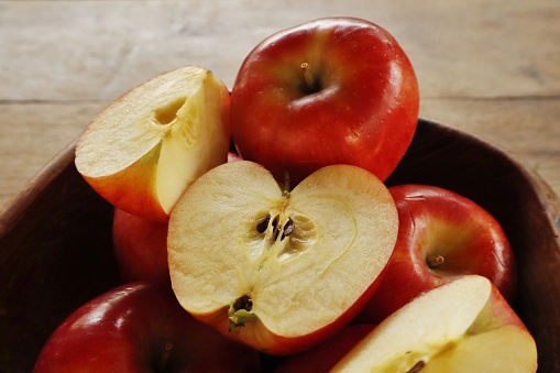 Fresh organic Red pop apple fruit welcomes summer in beautiful colors on a wooden table.