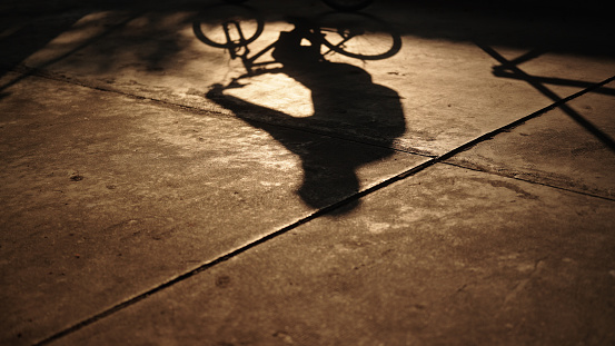 Shadow of man cycling bicycle.
