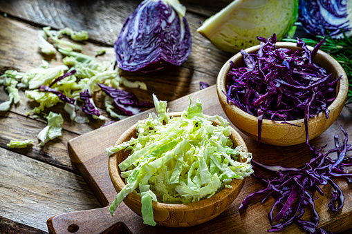 Fresh organic chopped red and green cabbage in a wooden bowl. High resolution 42Mp studio digital capture taken with Sony A7rII and Sony FE 90mm f2.8 macro G OSS lens